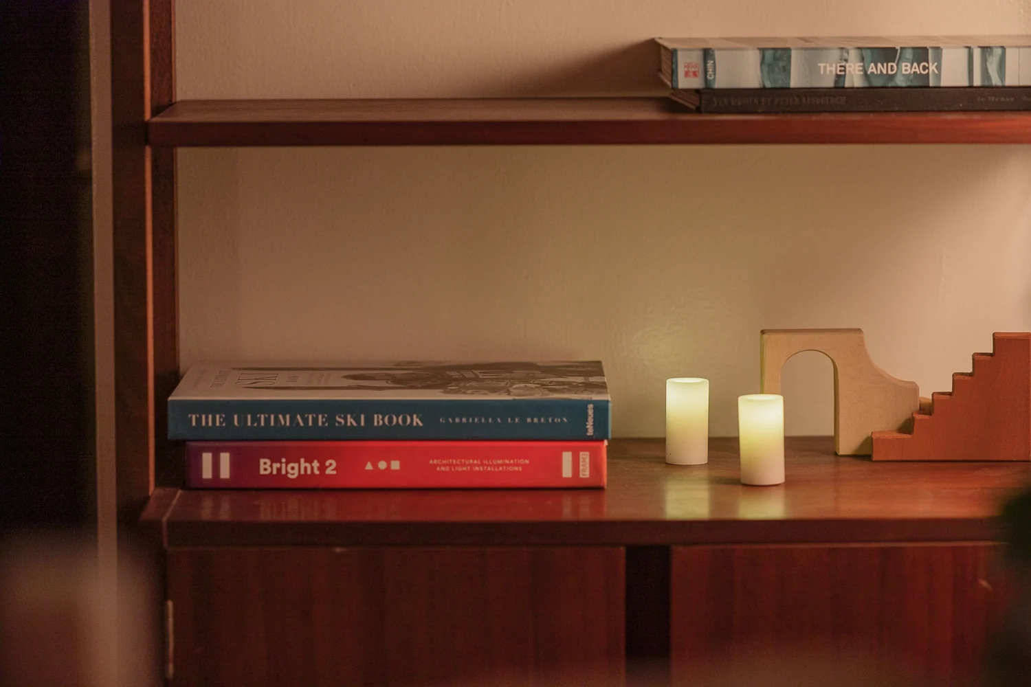 Two glowing Context candles on a bookshelf